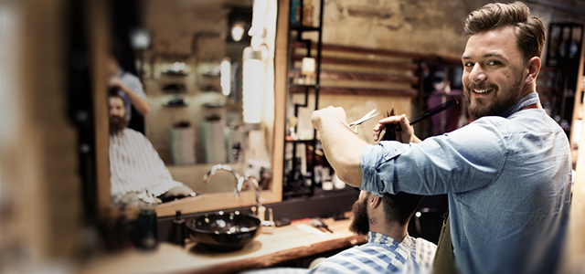 Frisör schneidet Kunden die Haare im Salon