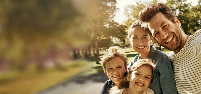 Mann macht ein Selfie von sich, seiner Frau, Tochter und Sohn